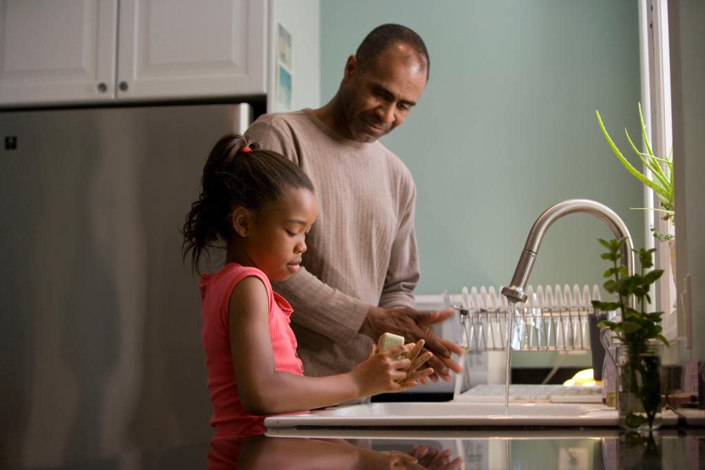 A father and his daughter washing their hands.