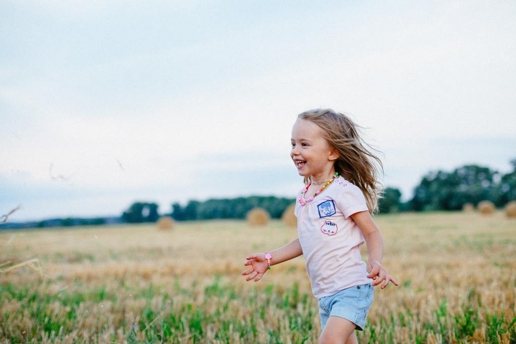 A girl running in an open field.